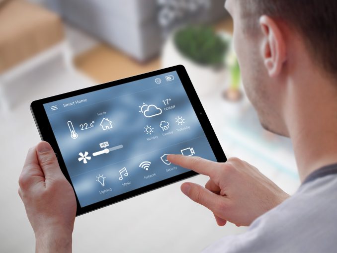 Smart home control on tablet. Interior of living room in the bac