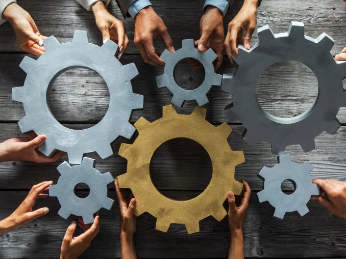 Business people joining gears