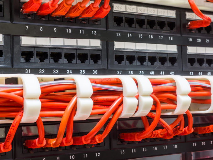Close up of red network cables connected to switch Halbleitertechnologie im Verbund mit flexiblen Schaltungskonfigurationen. © angelus iam - Fotolia