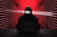Anonymous hacker with laptop in front of binary code cyber security